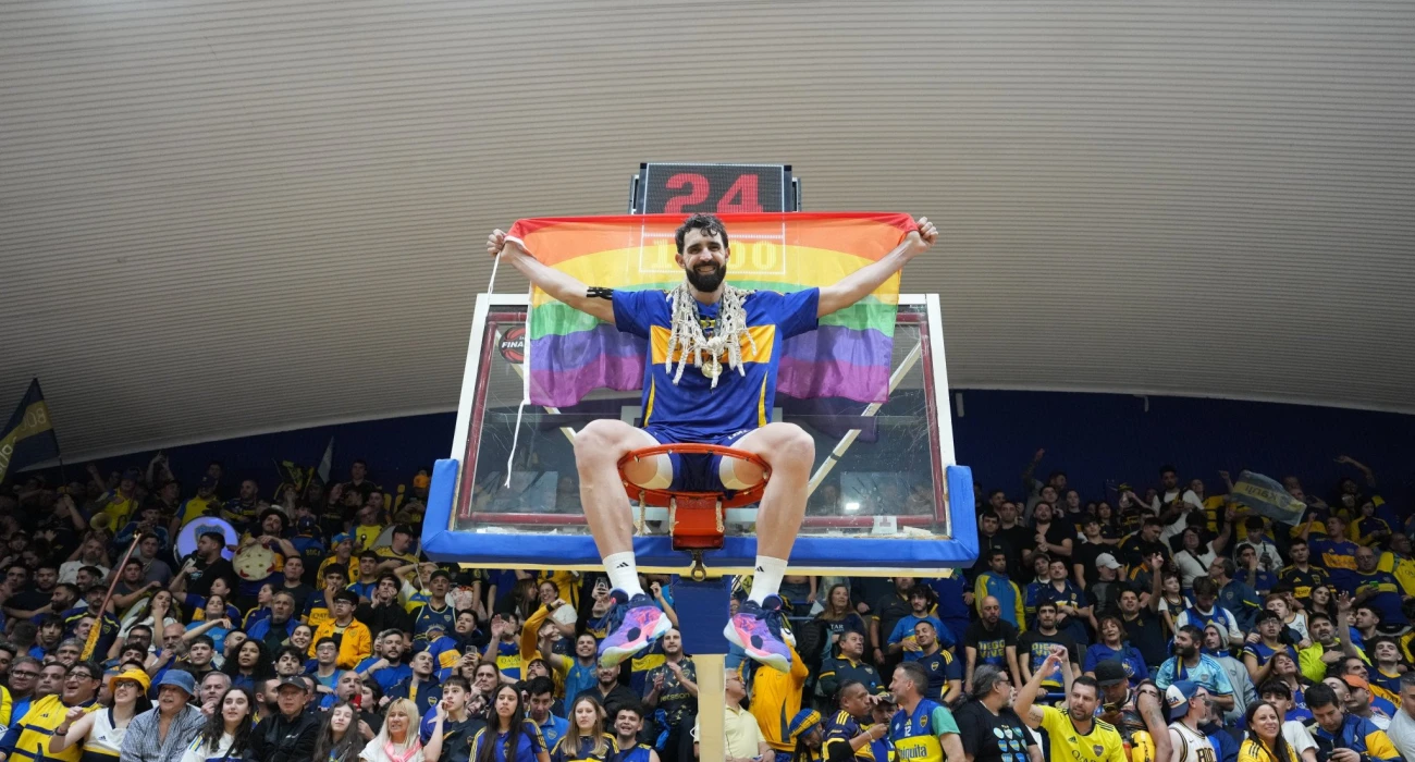 Γκέι επαγγελματίας μπασκετμπολίστας κερδίζει το πρωτάθλημα και γιορτάζει κρατώντας μια σημαία Pride